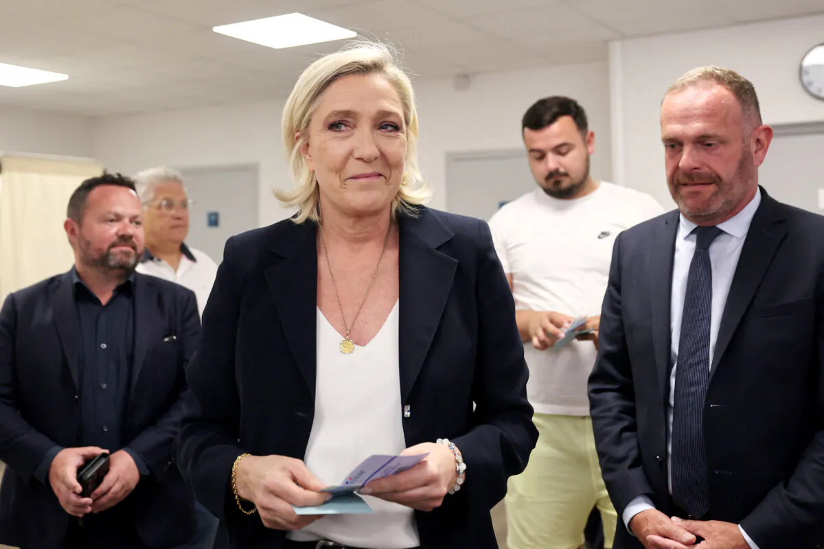Head of French National Rally party Marine Le Pen (C) holds ballots next to Mayor of Henin-Beaumont Steeve Briois (R), before voting in the first round of parliamentary elections in Henin-Beaumont, North of France, on June 30, 2024. (Francois Lo Presti/AFP via Getty Images)
