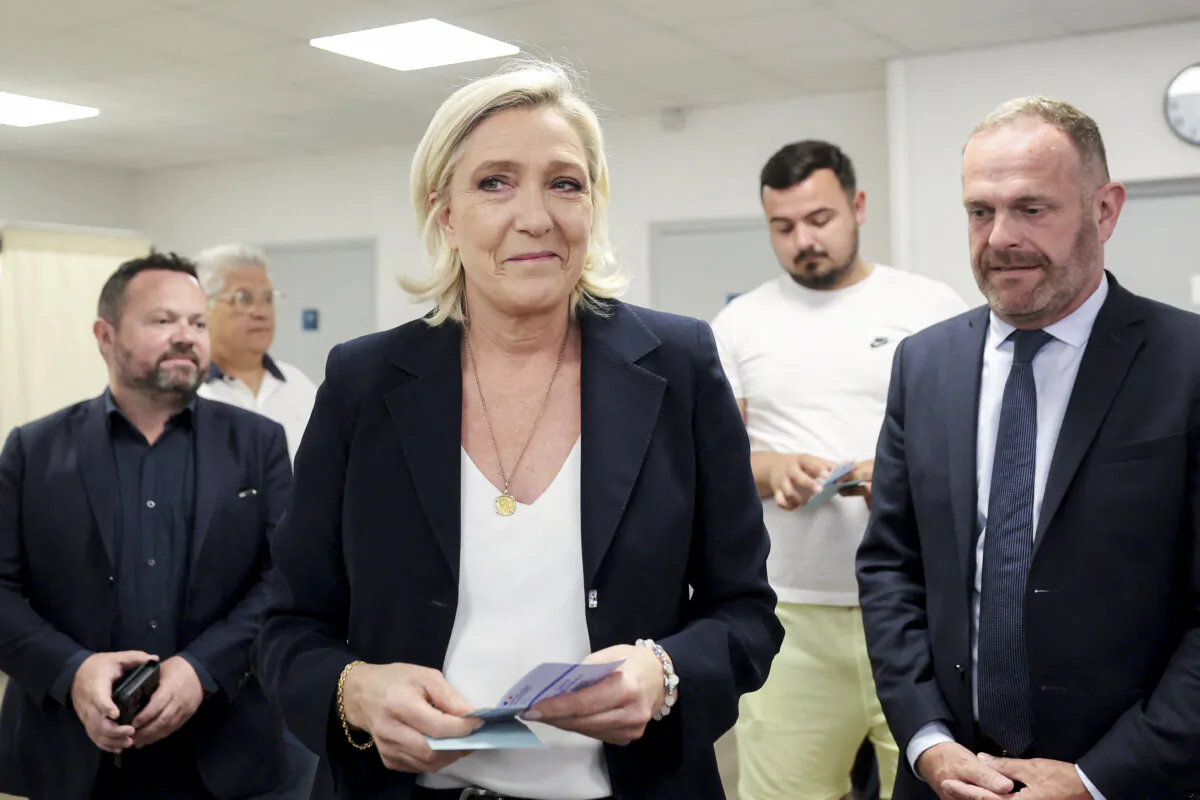 Head of French National Rally party Marine Le Pen (C) holds ballots next to Mayor of Henin-Beaumont Steeve Briois (R), before voting in the first round of parliamentary elections in Henin-Beaumont, North of France, on June 30, 2024. (Francois Lo Presti/AFP via Getty Images)