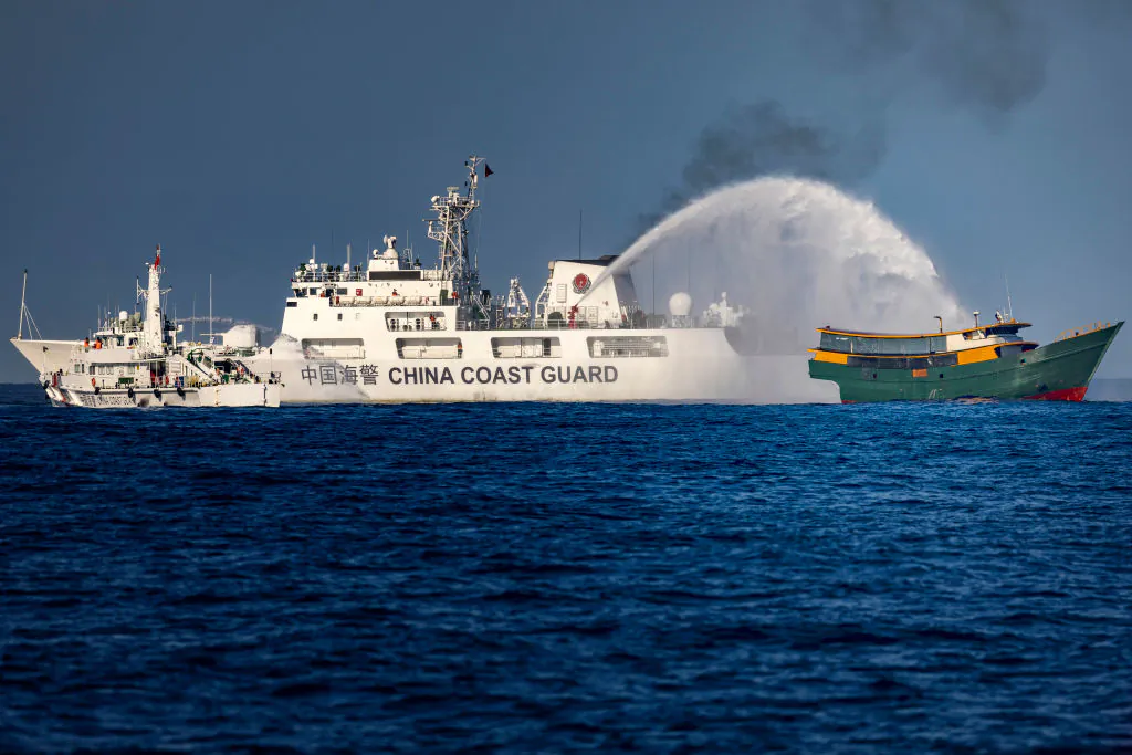 A Chinese Coast Guard ship fires a water cannon at a Philippine Navy chartered vessel, conducting a routine resupply mission to troops stationed at Second Thomas Shoal in the South China Sea, on March 5, 2024. (Ezra Acayan/Getty Images)