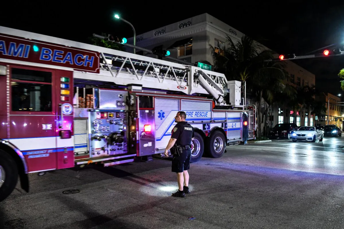 A Miami Beach police officer stands by a fire truck on Ocean Drive in Miami Beach, on March 22, 2021. (Chandan Khanna/AFP via Getty Images)