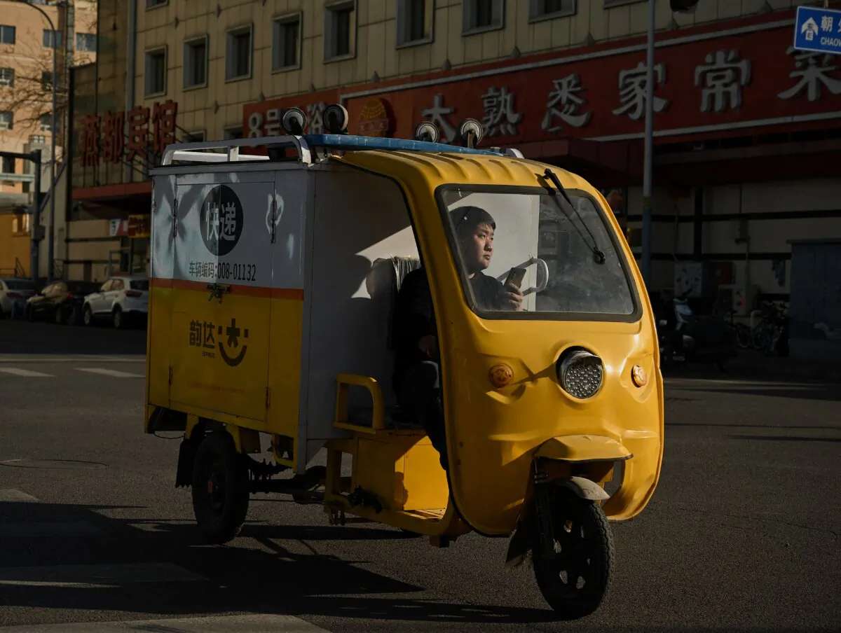 A delivery man drives his tricycle along a street in Beijing on December 20, 2021. (Noel Celis/AFP via Getty Images)