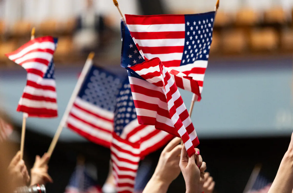 People wave U.S. flags in Oakland, Calif., on March 25, 2024. (John Fredricks/The Epoch Times)