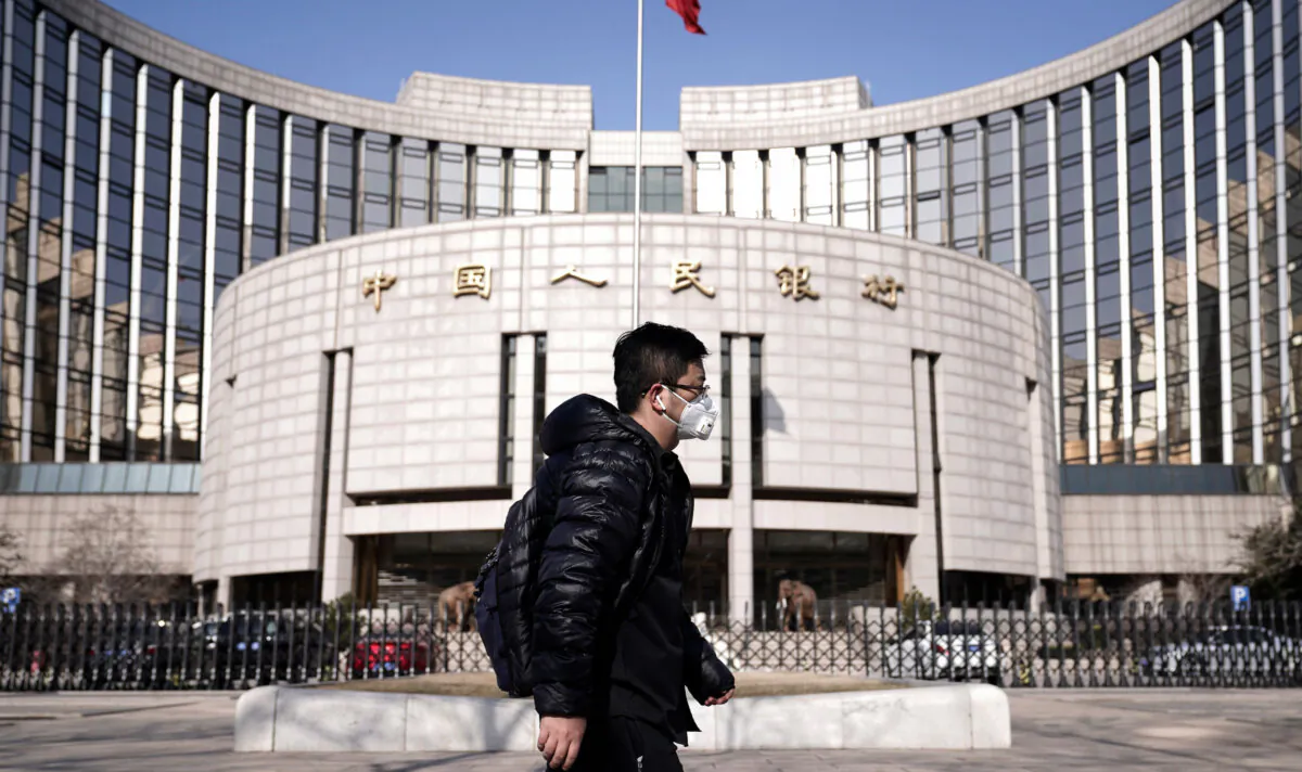 A man walks past the headquarters of the People's Bank of China, the central bank, amid the COVID-19 pandemic, in Beijing on Feb. 3, 2020. (Jason Lee/Reuters)