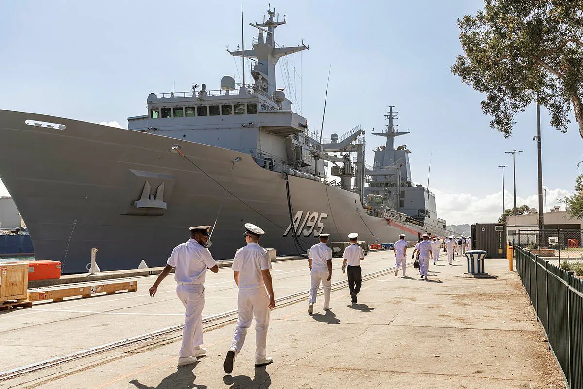 Junior Officers from the Western Pacific Naval Symposium Junior Officer Interaction Program walk towards HMAS Supply before touring the ship in Sydney, New South Wales. (Lucinda Allanson/Royal Australian Navy)