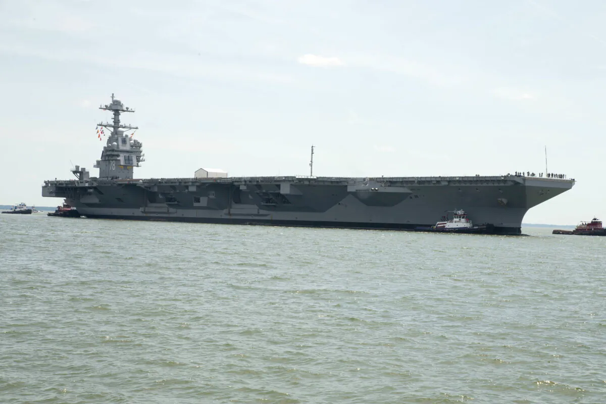 USS Gerald R. Ford (CVN78) is pushed by tug boats as the ship enters Huntington Ingalls Newport News Shipbuilding in Newport News, Va., on July 15, 2018. (Mass Communication Specialist 2nd Class Cat Campbell/U.S. Navy)