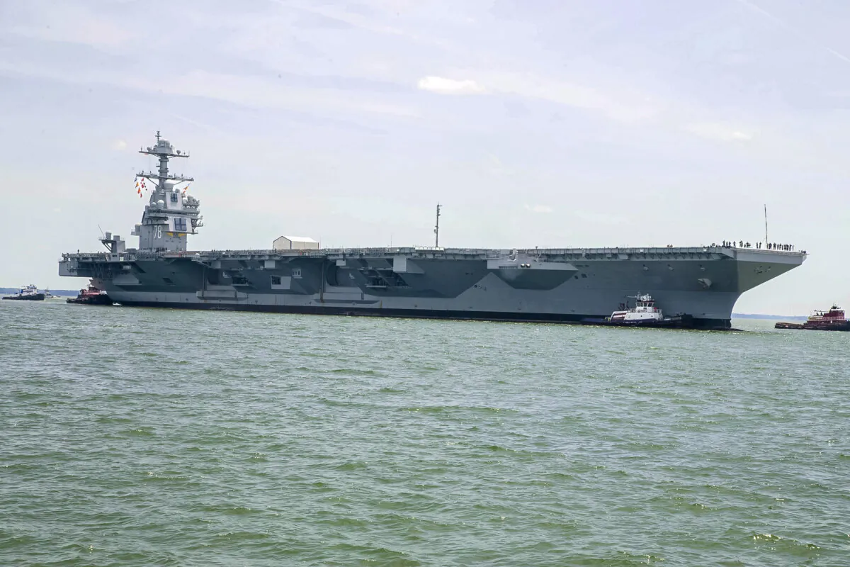USS Gerald R. Ford (CVN78) is pushed by tug boats as the ship enters Huntington Ingalls Newport News Shipbuilding in Newport News, Va., on July 15, 2018. (Mass Communication Specialist 2nd Class Cat Campbell/U.S. Navy)