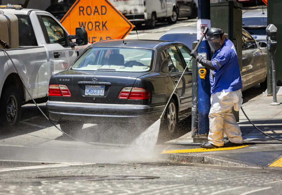 City workers powerwash the sidewalks of the Tenderloin District of San Francisco, Calif., on May 16, 2024. (John Fredricks/The Epoch Times)