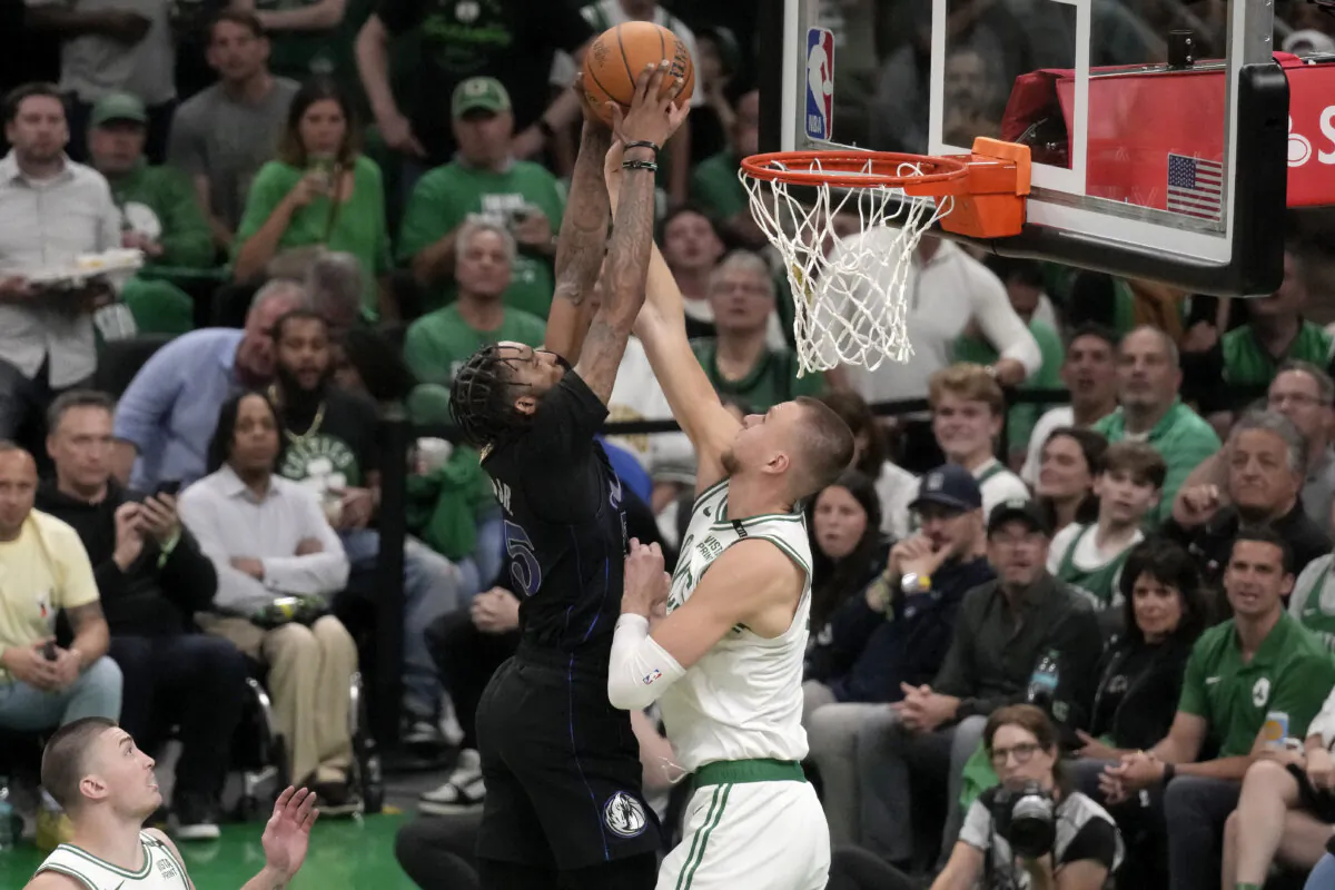 Boston Celtics center Kristaps Porzingis, right, blocks a shot by Dallas Mavericks forward Derrick Jones Jr. during the second half of Game 1 of NBA Finals in Boston on  June 6, 2024. (Charles Krupa/AP Photo)