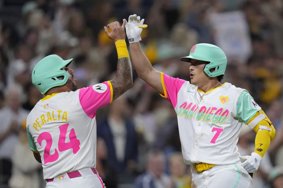 San Diego Padres' Ha-Seong Kim (R) celebrates with teammate David Peralta after hitting a two-run home run during the sixth inning of a baseball game against the Arizona Diamondbacks in San Diego on June 7, 2024. (Gregory Bull/AP Photo)