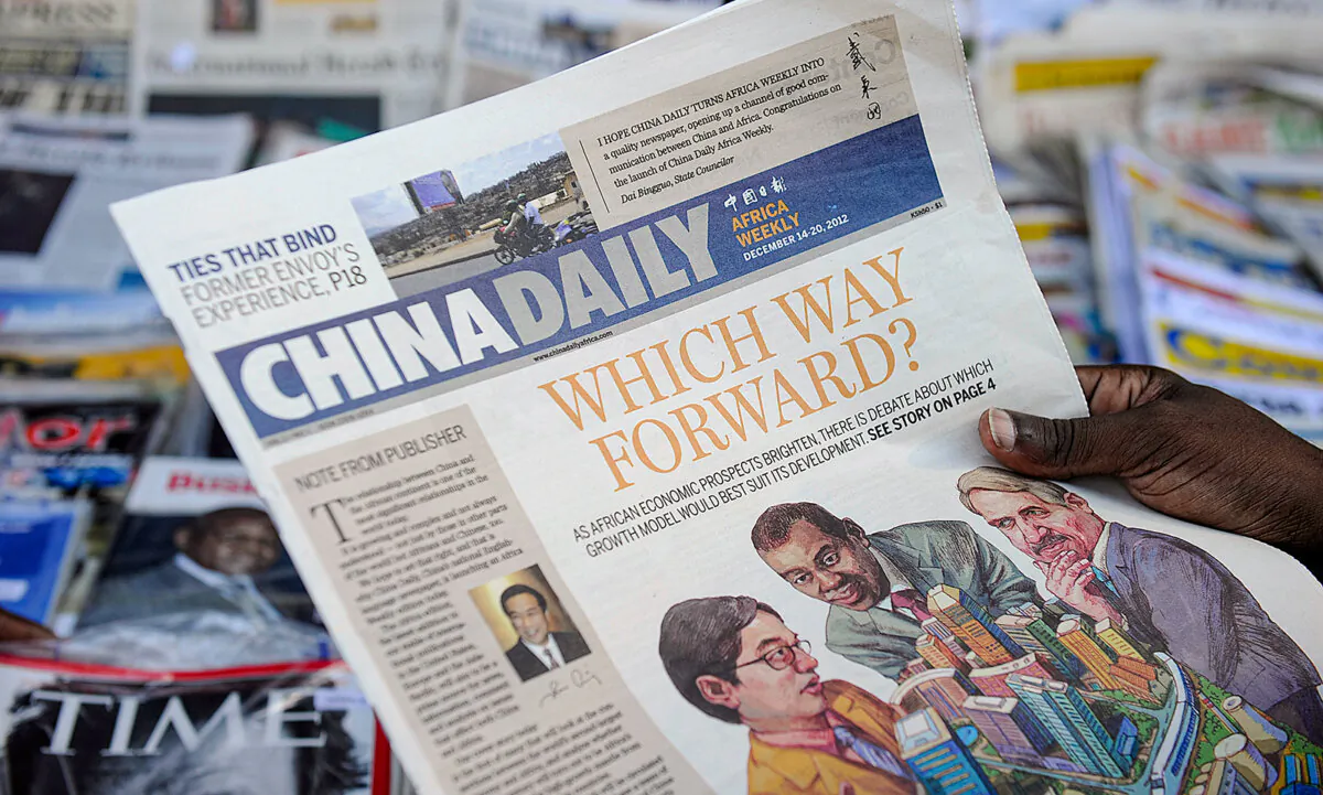 A newspaper consumer reads a copy of China Daily's Africa edition in front of a news stand in the Kenyan capital on Dec. 14, 2012. (Tony Karumba/AFP via Getty Images)