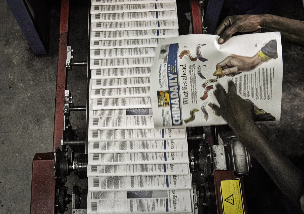 A technician inspects copies of Chinese owned newspaper, China Daily at the printing press in Nairobi, Kenya, in Dec. 2013. (Tony Karumba/AFP via Getty Images)