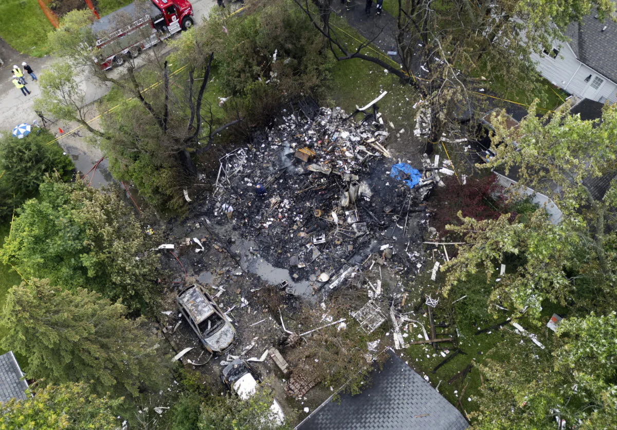 Investigators and firefighters remain on the scene after an explosion destroyed a home in unincorporated Lake Zurich, Ill., on June 5, 2024. (Paul Valade/Daily Herald via AP)
