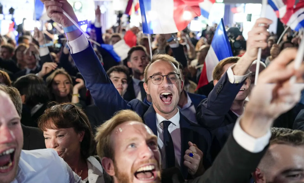 Supporters of French right-wing National Rally react at the party election night headquarters in Paris on June 9, 2024. (AP Photo/Lewis Joly)