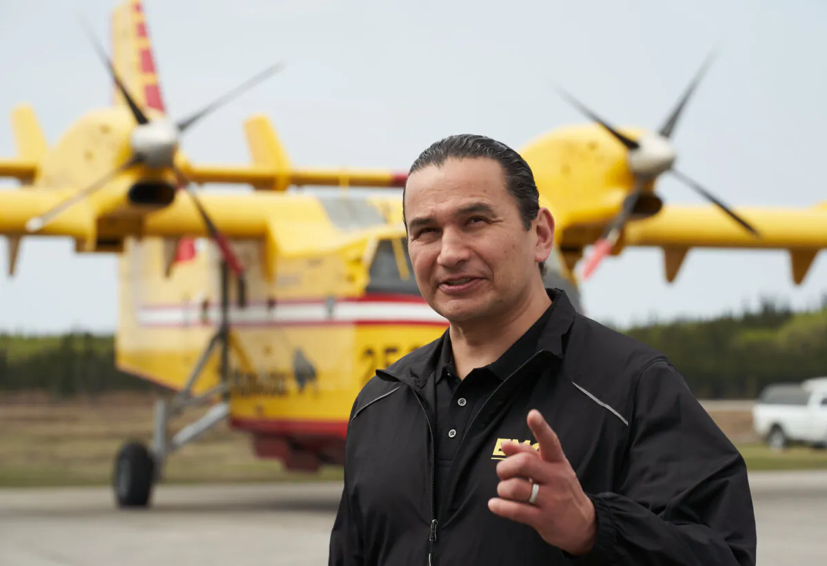 Manitoba Premier Wab Kinew speaks with firefighters at the Flin Flon airport in northern Manitoba on May 14, 2024. (The Canadian Press/David Lipnowski)