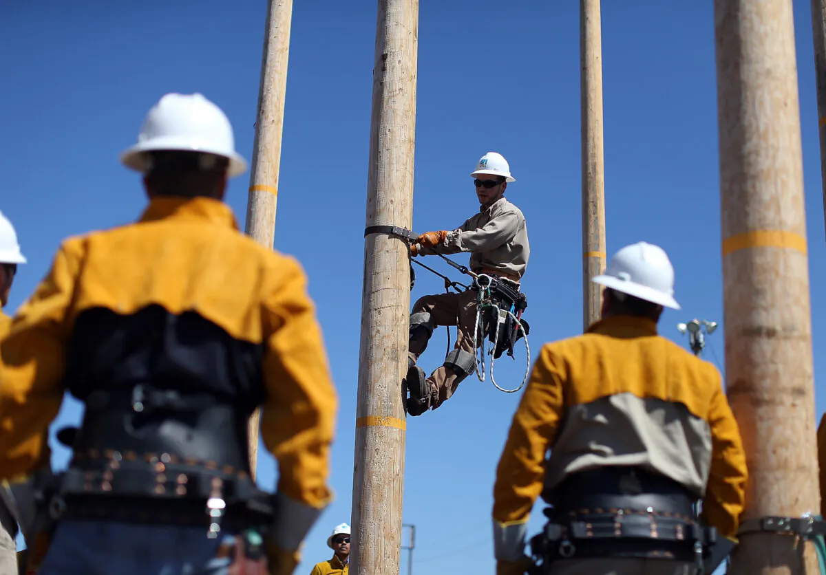 Students watch as Pacific Gas and Electric (PG&E) instructor Rick Johnson (C) demonstrates how to navigate a utility pole during the PG&E's PowerPathway Pole Climbing Capstone course at the PG&E pole climbing training facilityin Oakland, California on June 8, 2012. (Justin Sullivan/Getty Images)