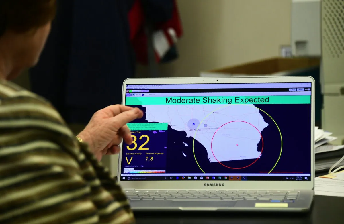 An employee of the Seismological Laboratory at California Institute of Technology (Caltech), points to a shake alert user display on a laptop screen, at the Caltech Seismological Laboratory in Pasadena, Calif., in a file photo. (Frederic Brown/AFP via Getty Images)