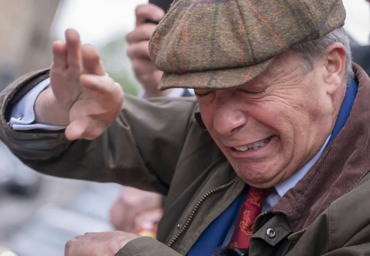 Nigel Farage shields his face after objects are thrown at him while he was campaigning in Barnsley, south Yorkshire, on June 11, 2024. (Danny Lawson/PA)