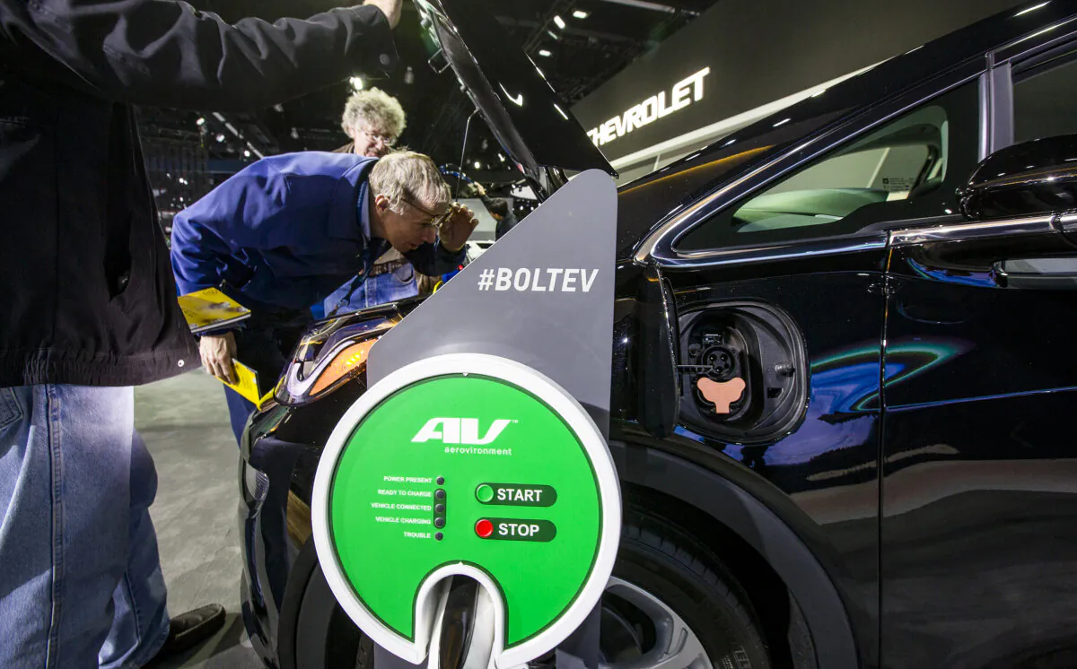 People look under the hood of a Chevrolet Bolt EV at the auto trade show, AutoMobility LA, at the Los Angeles Convention Center in Los Angeles, Calif., on Nov. 29, 2018. (David McNew/Getty Images)