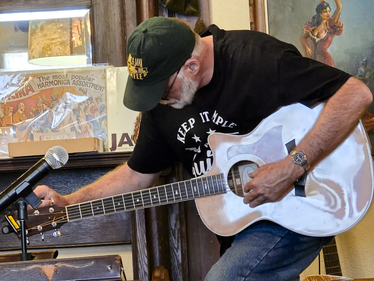 Wayne, 56, tunes an electric acoustic guitar during an informal jam session in Springerville, Ariz., on May 8, 2024. (Allan Stein/The Epoch Times)