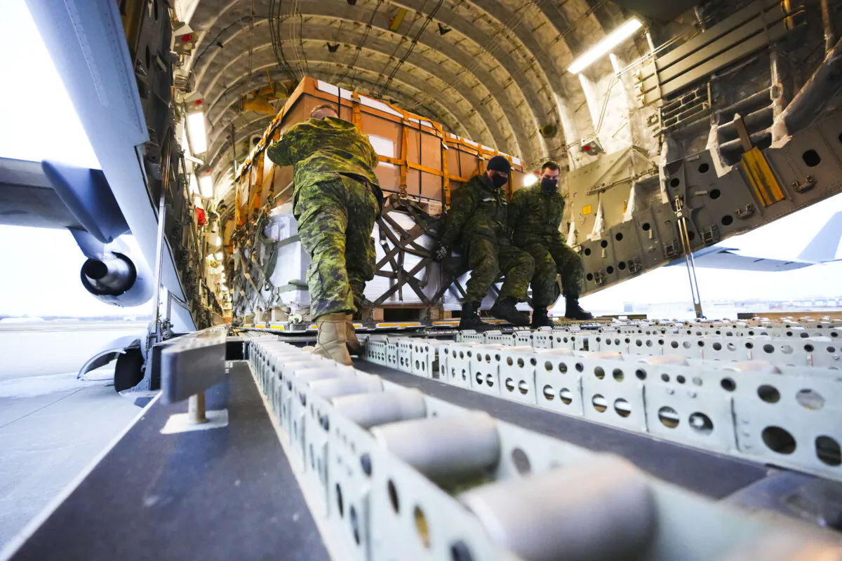 Royal Canadian Air Force personnel load non-lethal and lethal aid at CFB Trenton, Ont., bound for the Ukraine via Poland, Ont., on March 7, 2022. (The Canadian Press/Sean Kilpatrick)