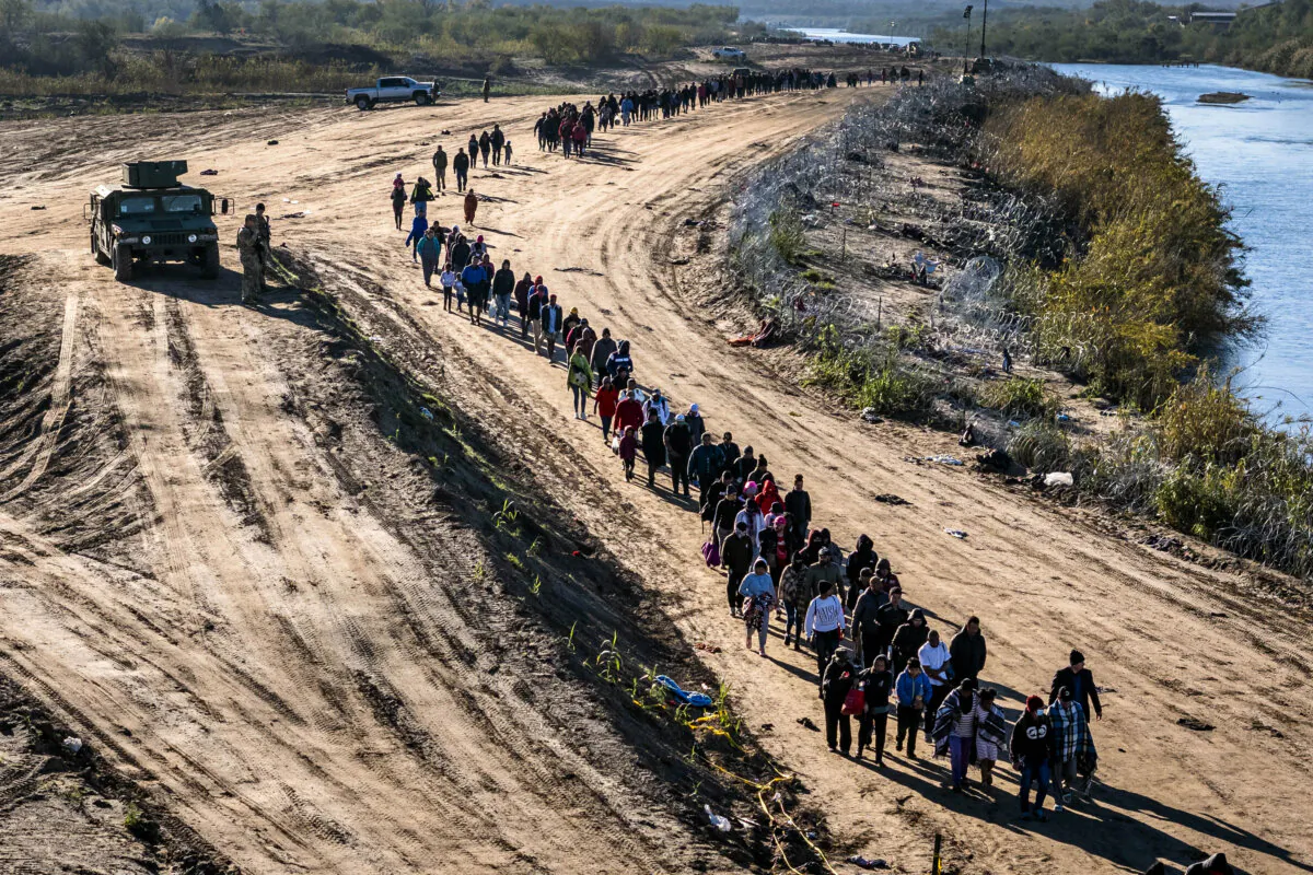 A group of more than 1,000 illegal immigrants walks toward a U.S. Border Patrol field processing center after they crossed the Rio Grande from Mexico in Eagle Pass, Texas, on Dec. 18, 2023. (John Moore/Getty Images)