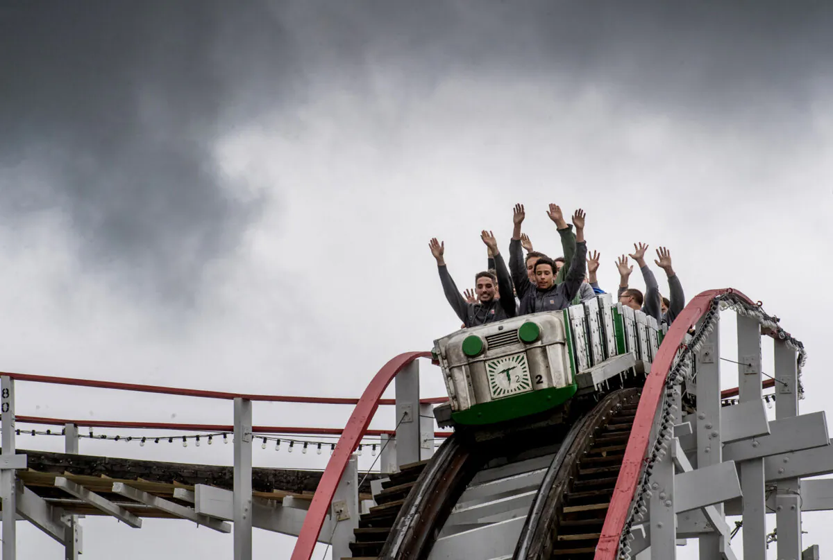 Guests ride the Thunderbolt under a menacing sky on Saturday, April 22, 2023, at Kennywood, which opened for the 2023 season. (Pittsburgh Post-Gazette/TNS)