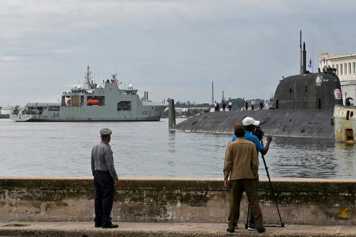 People watch Canadian navy patrol boat HMCS Margaret Brooke passing by Russian nuclear-powered cruise missile submarine Kazan as it enters Havana's bay, Cuba, on June 14, 2024. (Reuters/Stringer)