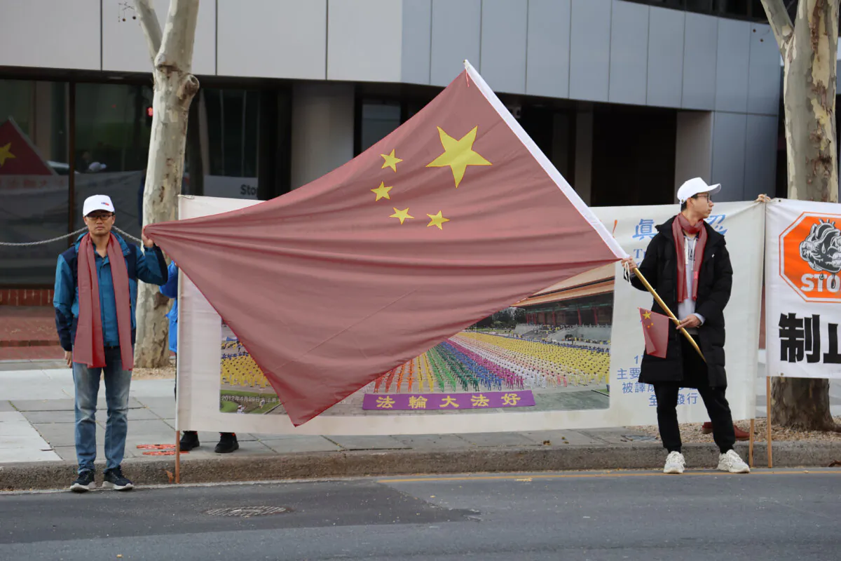 Pro-CCP supporters attempting to obscure a banner that describes the peaceful meditation practice Falun Gong, which is currently being persecuted in China by the Chinese Communist Party, taken in Adelaide, Australia on June 15, 2024. (Courtesy of Yangyang Lu)