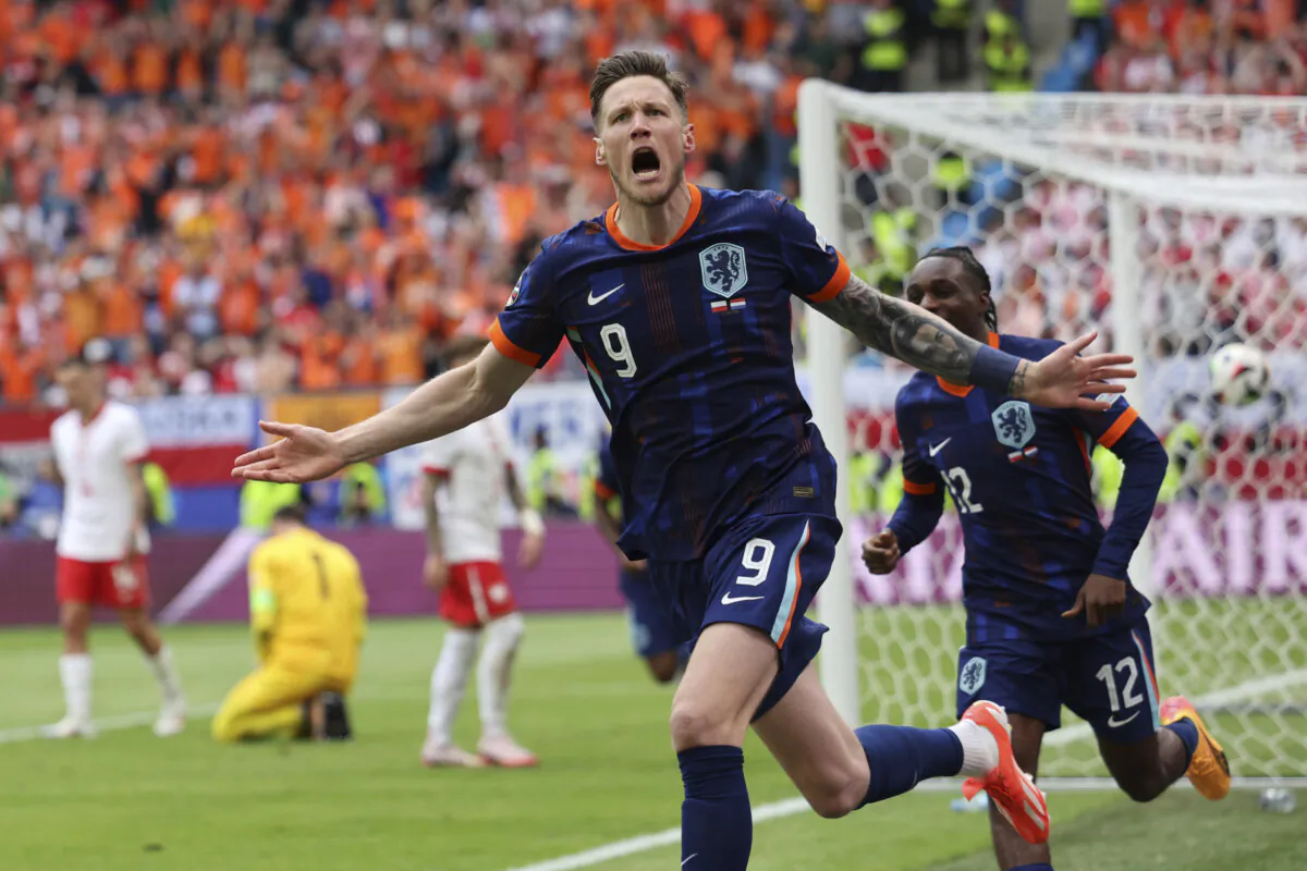 Wout Weghorst of the Netherlands (L) celebrates his side's second goal with his team mates during a Group D match between Poland and the Netherlands at the Euro 2024 soccer tournament in Hamburg, Germany, on June 16, 2024. (Jens Buettner/dpa via AP)