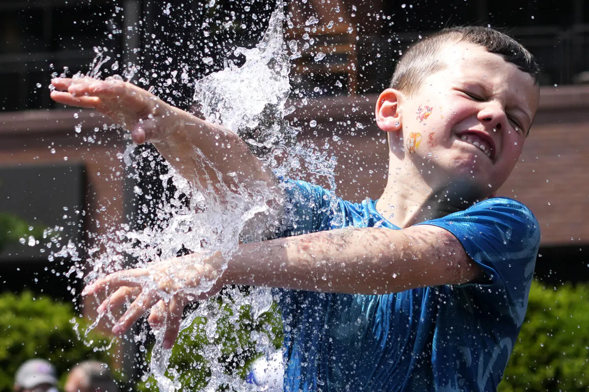 A boy cools off at a fountain outside Wrigley Field before a baseball game between the Chicago Cubs and St. Louis Cardinals as hot weather descends upon the Chicago area on June 16, 2024. (Nam Y. Huh/AP Photo)