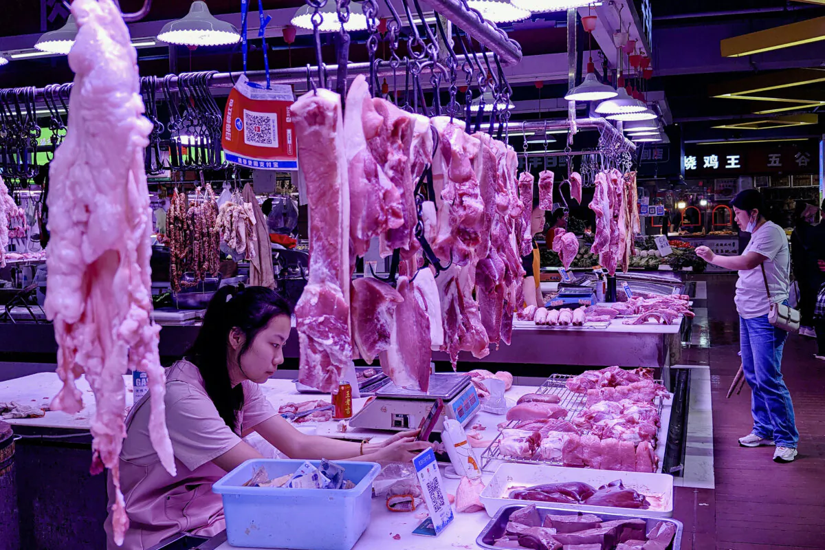 A vendor selling pork meat waits for customers at a market in Wuhan, in central China's Hubei Province, on April 15, 2024. STR/AFP via Getty Images)