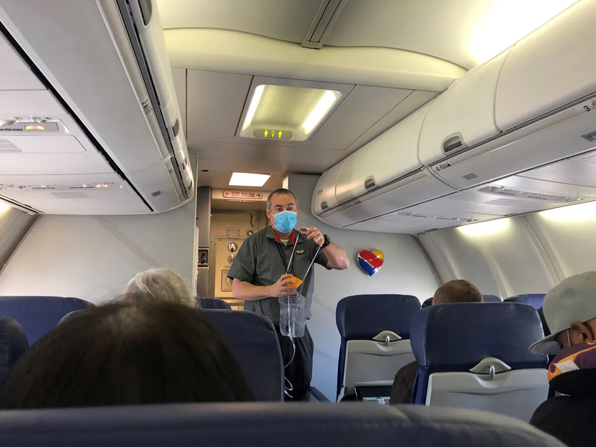 A flight attendant, wearing one mask, demonstrates the use of an oxygen mask at the outset of flight from Burbank to Las Vegas. Unruly passengers are an ongoing problem on commercial flights. (Christopher Reynolds/Los Angeles Times/TNS)