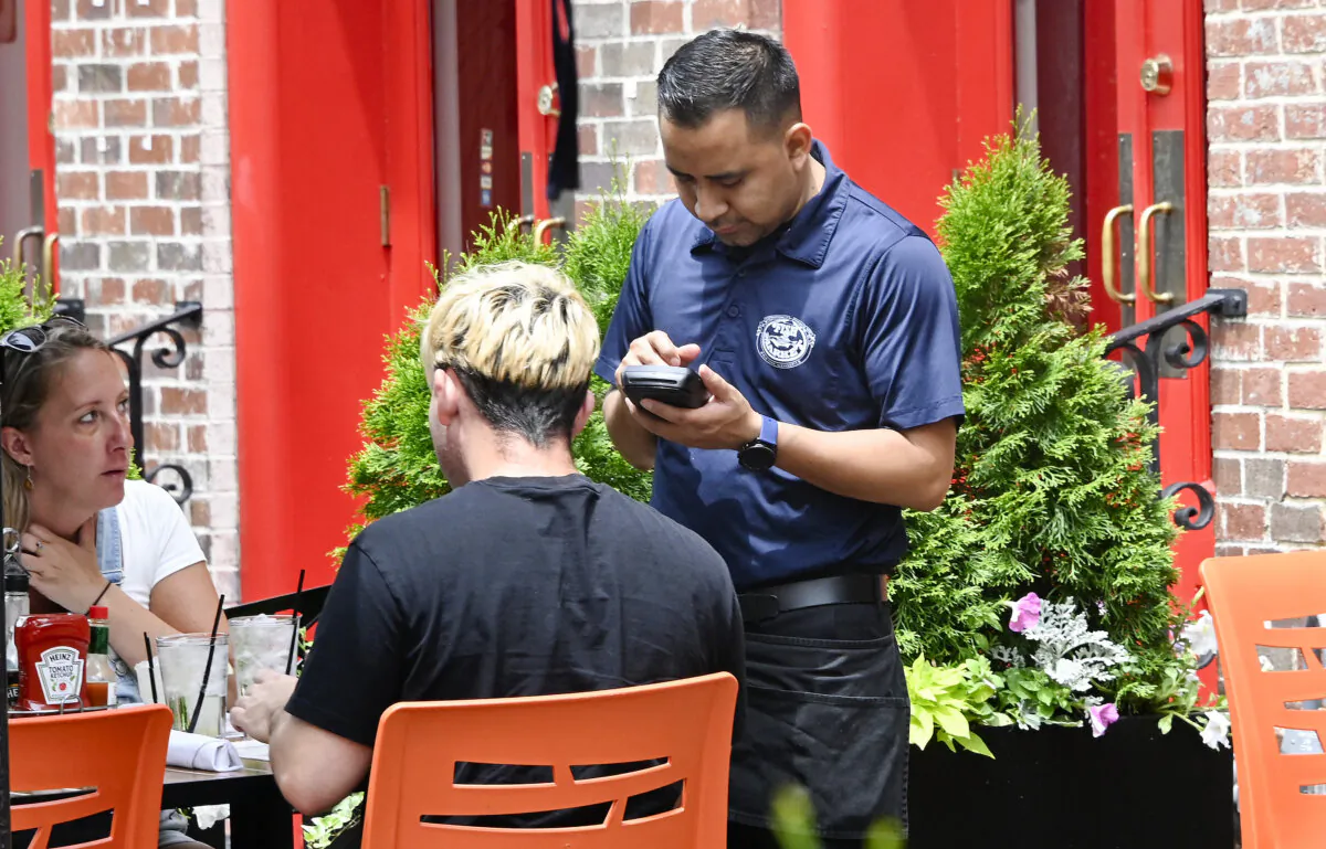 A waiter works at a restaurant in Alexandria, Va., on June 3, 2022. (Olivier Douliery/AFP via Getty Images)