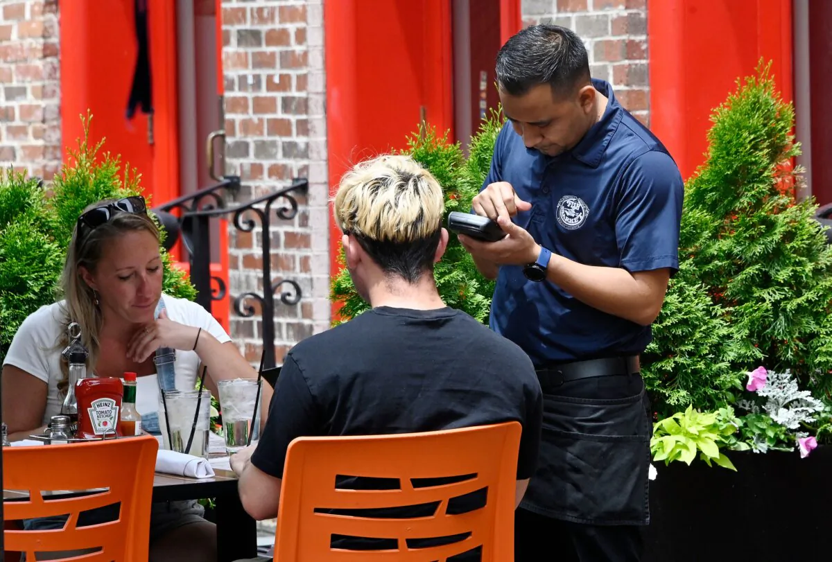 A waiter works at a restaurant in Alexandria, Va., on June 3, 2022. (Olivier Douliery/AFP via Getty Images)