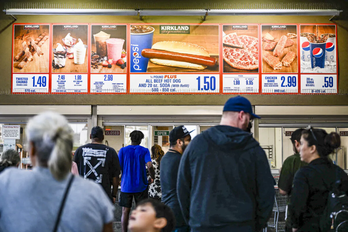 Customers wait in line to order below signage for the Costco Kirkland Signature $1.50 hot dog and soda combo, which has maintained the same price since 1985 despite consumer price increases and inflation, at the food court outside a Costco Wholesale Corp. store in Hawthorne, Calif., on June 14, 2022. (Patrick T. Fallon/AFP via Getty Images)