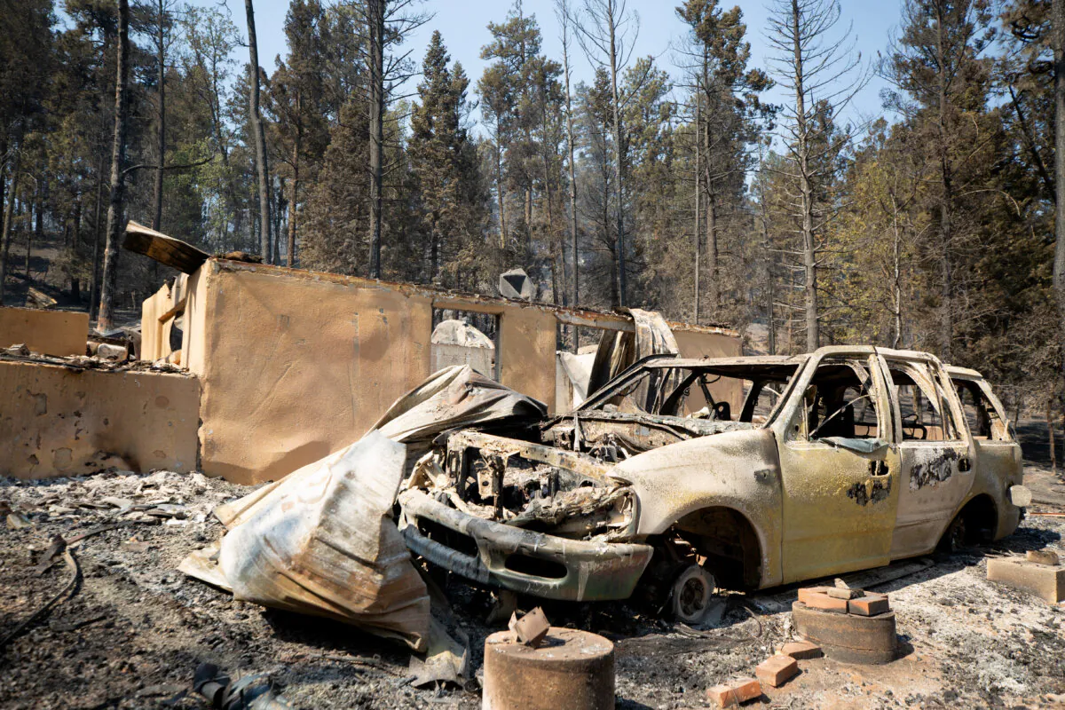 A burned car stands in front of a ruined building as the South Fork Fire burned most of the structures in Cedar Creek after mass evacuations of the village of Ruidoso, N.M., on June 18, 2024. (Kaylee Greenlee Beal/Reuters)