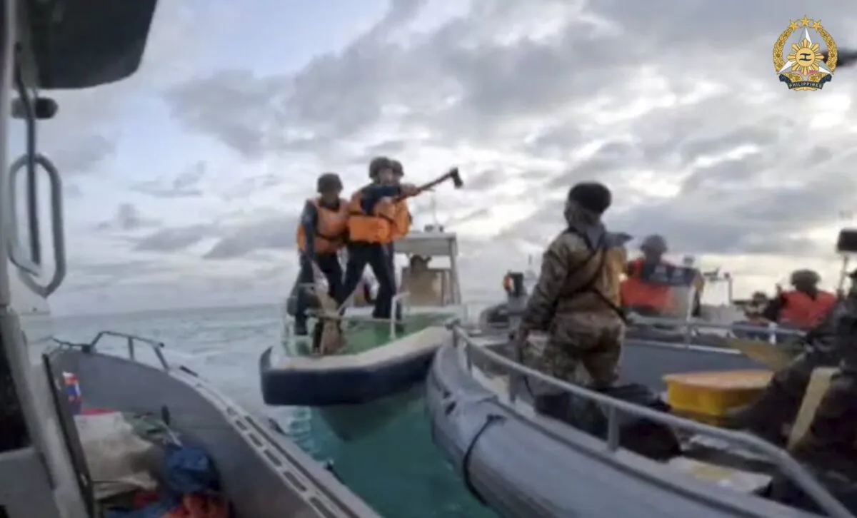 In this handout photo provided by Armed Forces of the Philippines, Chinese Coast Guard hold knives and machetes as they approach Philippine troops on a resupply mission in the Second Thomas Shoal at the disputed South China Sea on June 17, 2024. The Philippine military chief demanded Wednesday that China return several rifles and equipment seized by the Chinese coast guard in a disputed shoal and pay for damage in an assault he likened to an act of piracy in the South China Sea. (Armed Forces of the Philippines via AP)