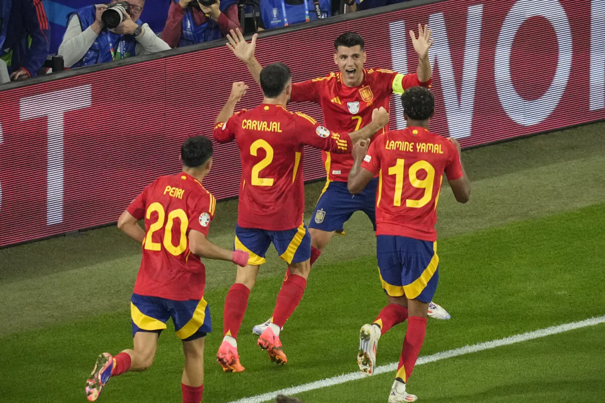 Spain's Alvaro Morata, top, celebrates after Italy's Riccardo Calafiori, right, lies face down on the pitch after scoring an own goal during a Group B match between Spain and Italy at the Euro 2024 soccer tournament in Gelsenkirchen, Germany, on June 20, 2024. (Andreea Alexandru/AP Photo)