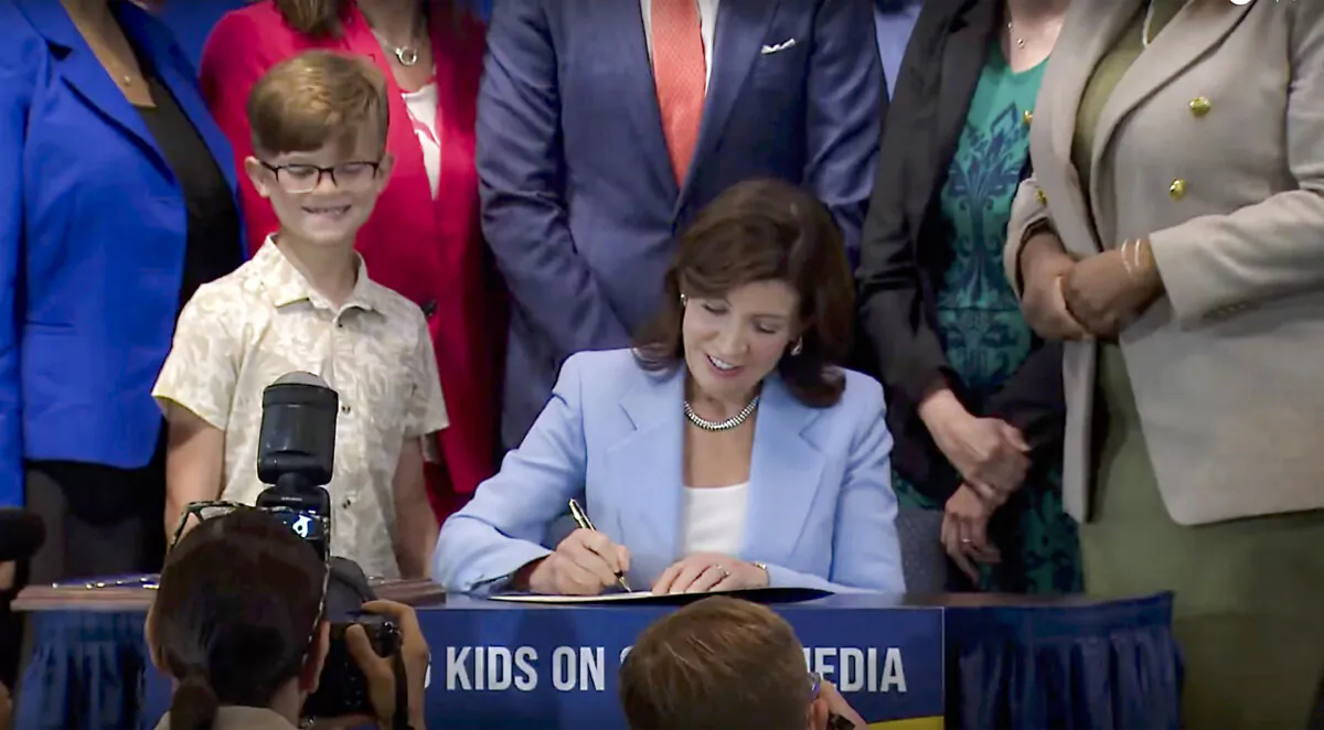 New York Gov. Kathy Hochul signs a bill in New York on June 20, 2024. Hochul signed a bill that would allow parents to block their children from getting social media posts suggested by a platform's algorithm, a move to limit feeds critics argue are addictive. (Office of the New York Governor via AP)
