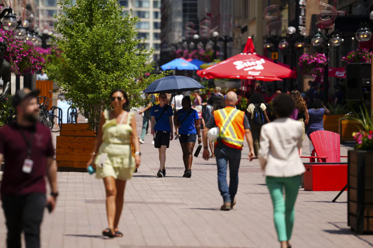 People make their way through downtown Ottawa on June 18, 2024, as temperatures hit 32C in what meteorologists called a heat dome. (The Canadian Press/Sean Kilpatrick)