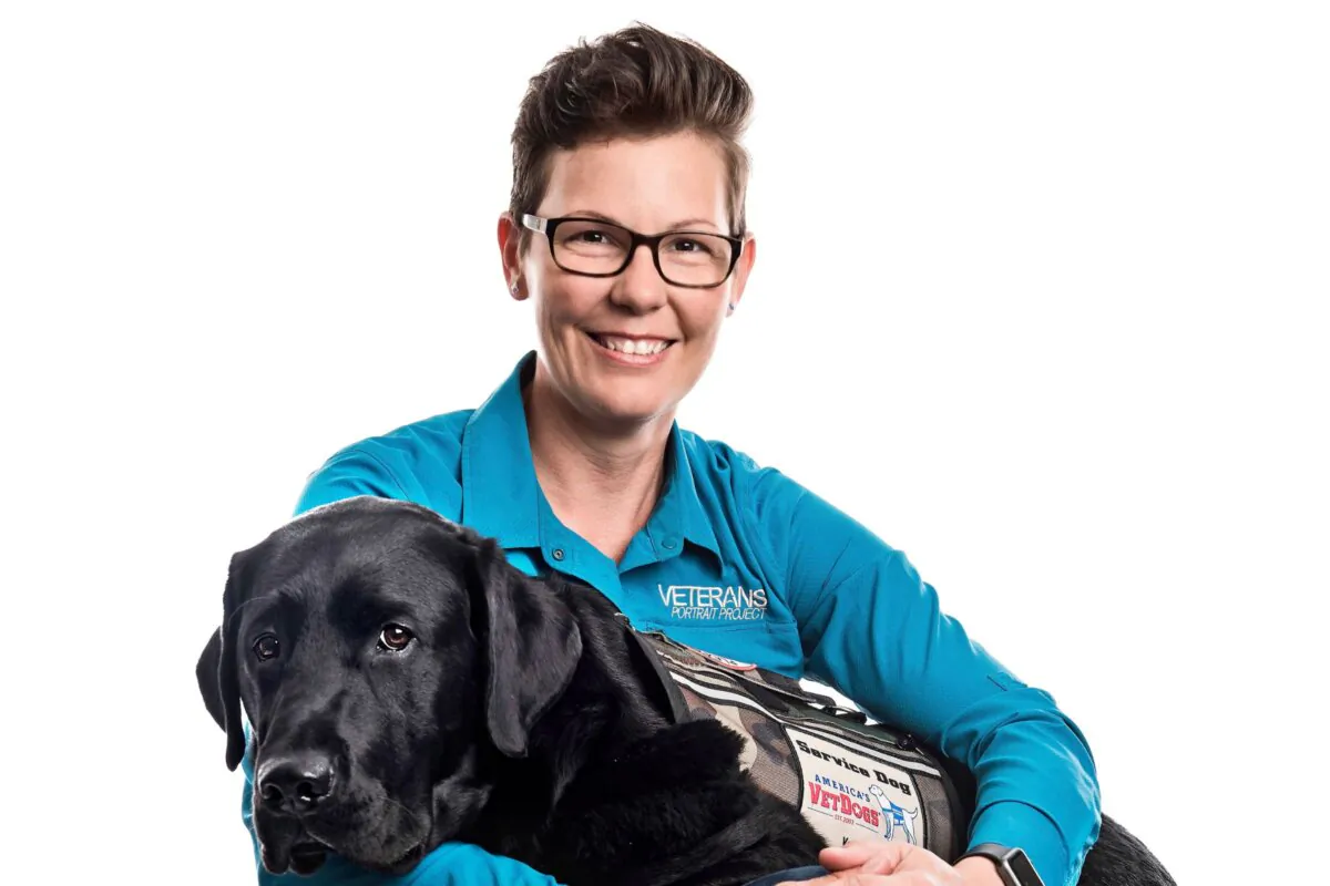 Stacy Pearsall with her
service dog, Charlie,
provided by the charity
America’s VetDogs. She takes moving portraits of veterans that have been displayed at national exhibits across the country. (Des'ola Mecozzi)