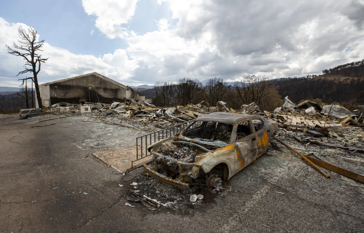 A charred car and the remains of the Swiss Chalet Hotel are pictured after being destroyed by the South Fork Fire in the mountain village of Ruidoso, N.M., on June 22, 2024.  (Andres Leighton/AP Photo)
