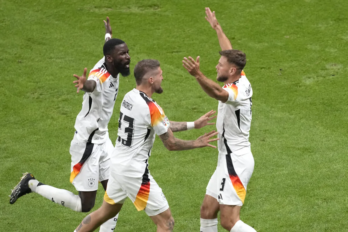 Germany's Niclas Fuellkrug (R) celebrates with Germany's Antonio Ruediger (L) and Germany's Robert Andrich after scoring his side's second goal during a Group A match between Switzerland and Germany at the Euro 2024 soccer tournament in Frankfurt, Germany, on June 23, 2024. (Michael Probst/AP Photo)