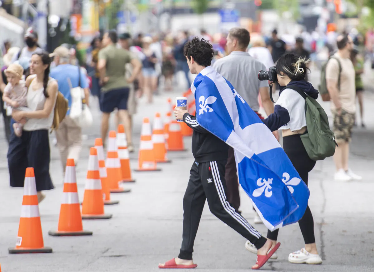 A man wears a Quebec flag during a Saint-Jean-Baptiste Day event in Montreal on June 24, 2022. (The Canadian Press/Graham Hughes) 