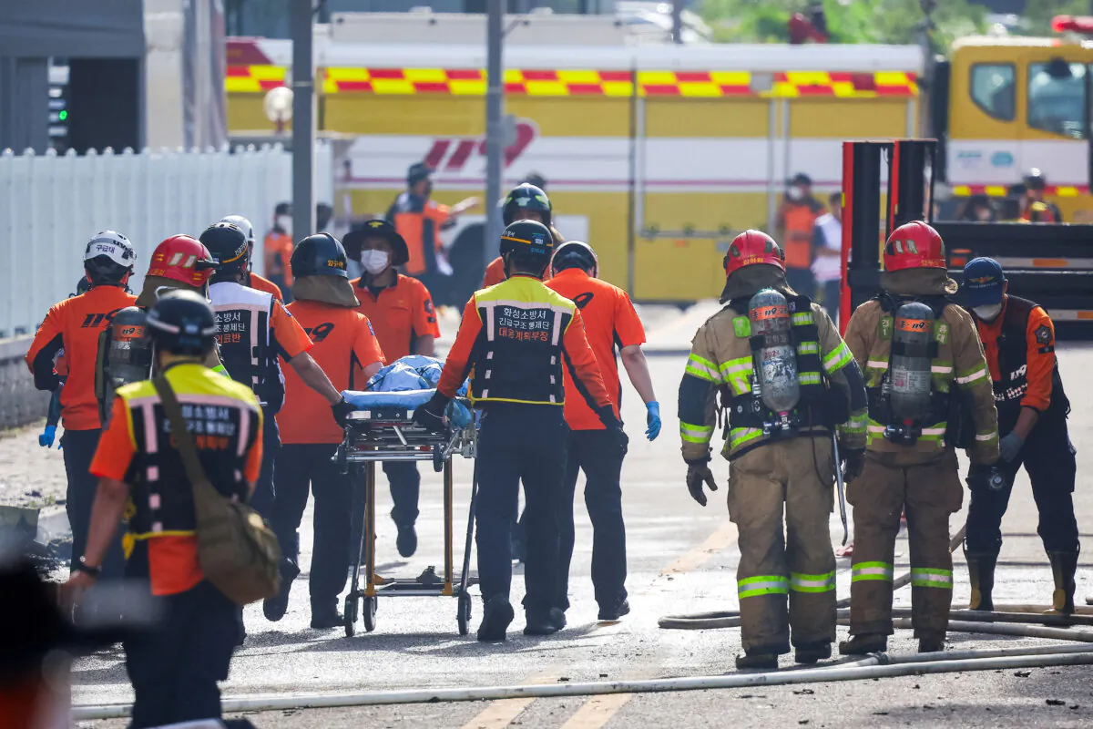 Emergency personnel carry the body of a person killed in a deadly fire at a lithium battery factory owned by South Korean battery maker Aricell, in Hwaseong, South Korea, on June 24, 2024. (Kim Hong-ji/Reuters)