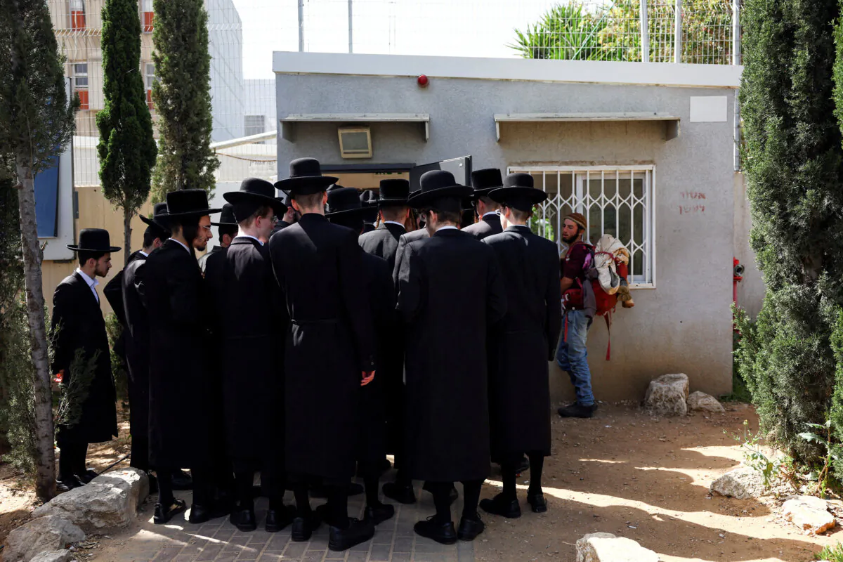 Ultra-Orthodox Jews line up at an Israeli draft office to process their exemptions from mandatory military service at a recruitment base in Kiryat Ono, Israel, on March 28, 2024. (Hannah McKay/Reuters)