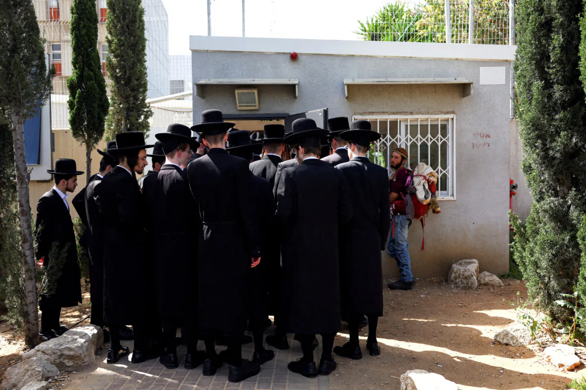 Ultra-Orthodox Jews line up at an Israeli draft office to process their exemptions from mandatory military service at a recruitment base in Kiryat Ono, Israel, on March 28, 2024. (Hannah McKay/Reuters)