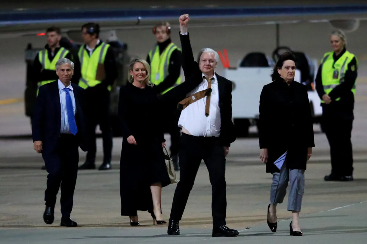WikiLeaks founder Julian Assange (C) gestures as he arrives at Canberra Airport in Canberra, Australia on June 26, 2024. (Roni Bintang/Getty Images)