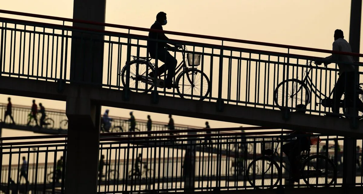People walk or ride bicycles over a bridge in Dubai, United Arab Emirates, on April 2, 2020. (Karim Sahib/AFP via Getty Images)