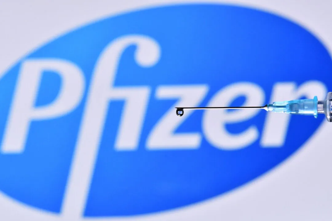 An illustration picture shows a drop from a syringe with the logo of US pharmaceutical company Pfizer on Nov. 17, 2020. (Justin Tallis/AFP via Getty Images)